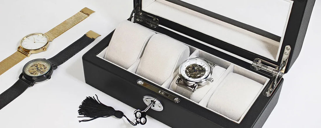 boite montre noir avec interieur blanc dedant il ya 1 montre en argent et deux autres montre a l'exterieur en or et l'autre noir 